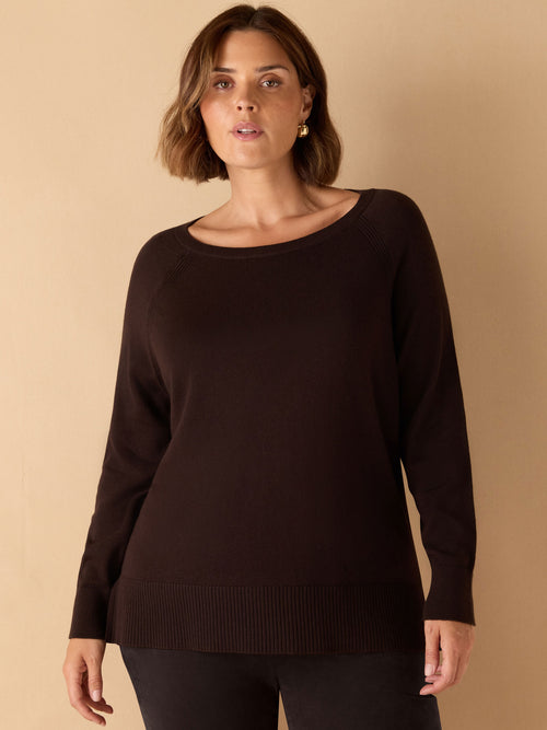 Woman wearing a brown sweater against a beige background