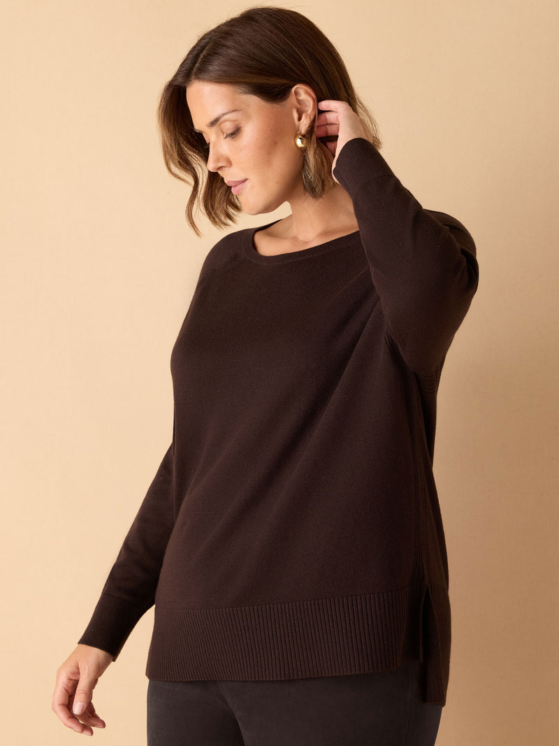 Woman wearing a brown sweater against a beige background
