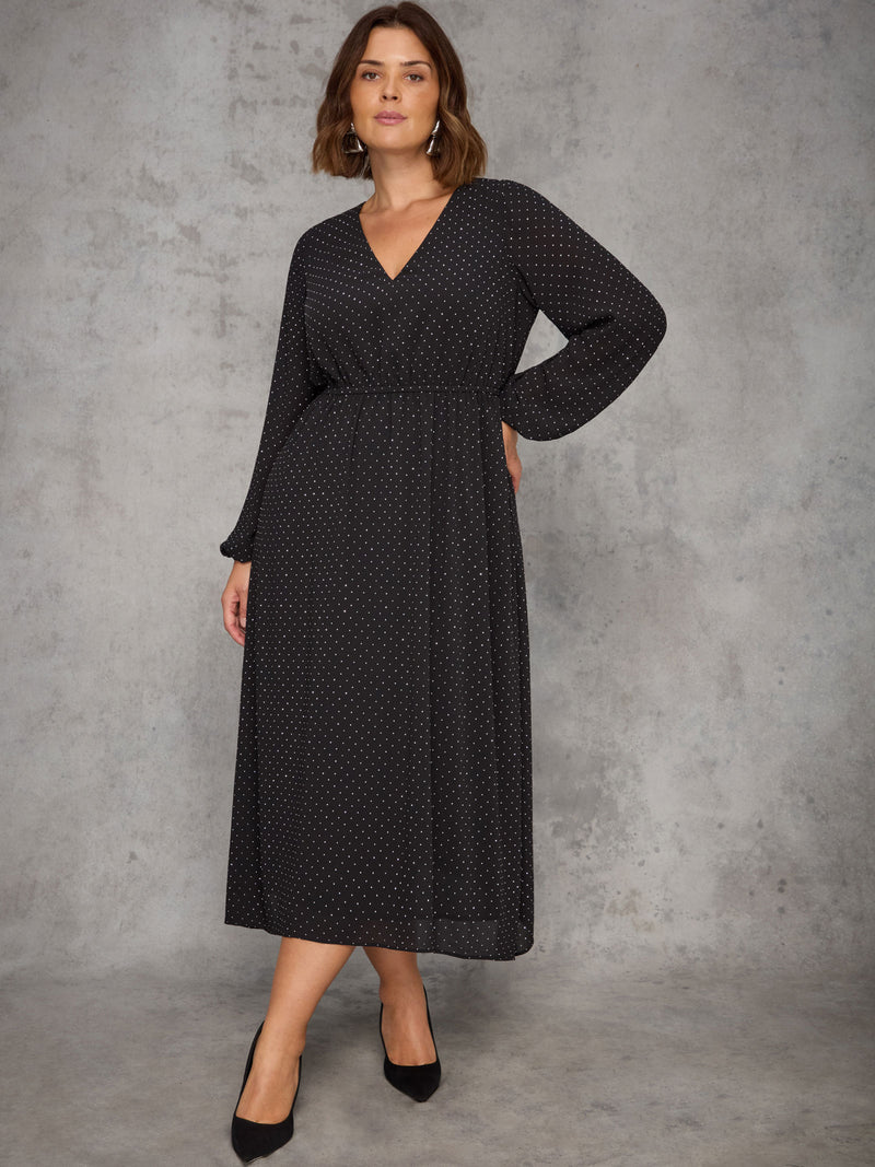 Woman wearing a black sparkle dress against a gray background