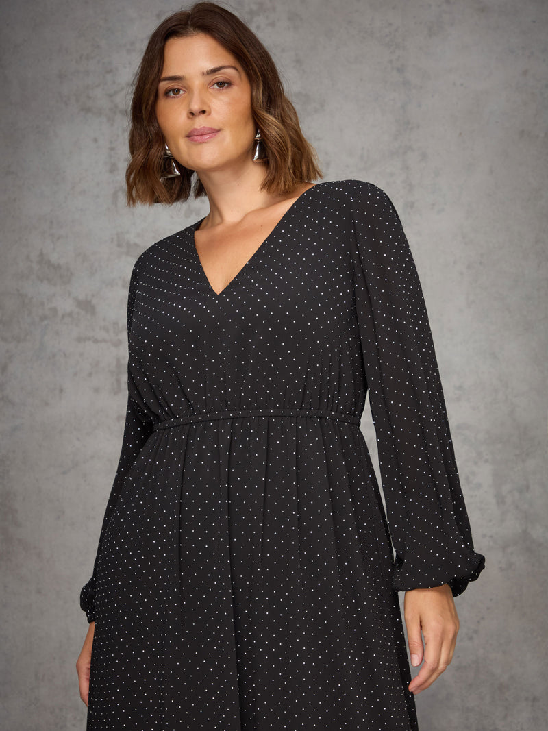 Woman wearing a black sparkle dress against a gray background