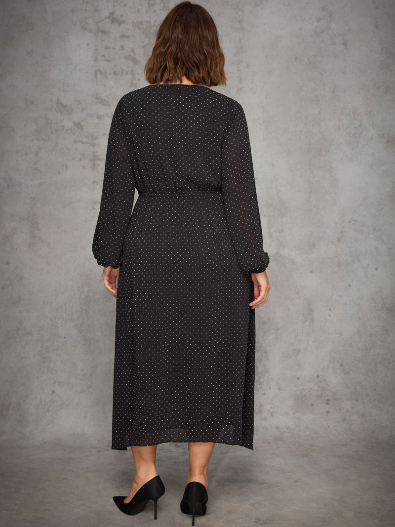 Woman wearing a black sparkle dress against a gray background