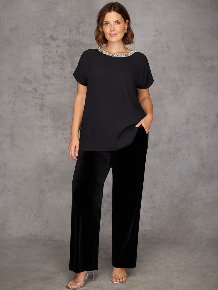 Woman wearing a black outfit with a textured gray background