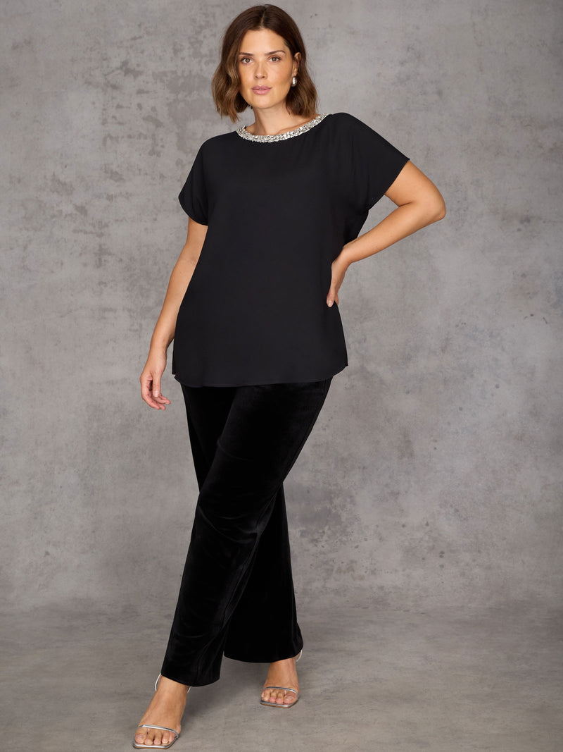 Woman wearing a black outfit against a gray background