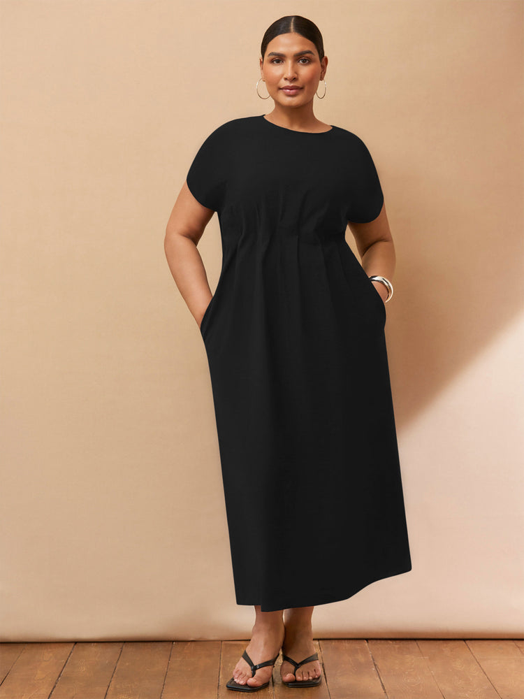 Woman wearing a black dress against a beige background