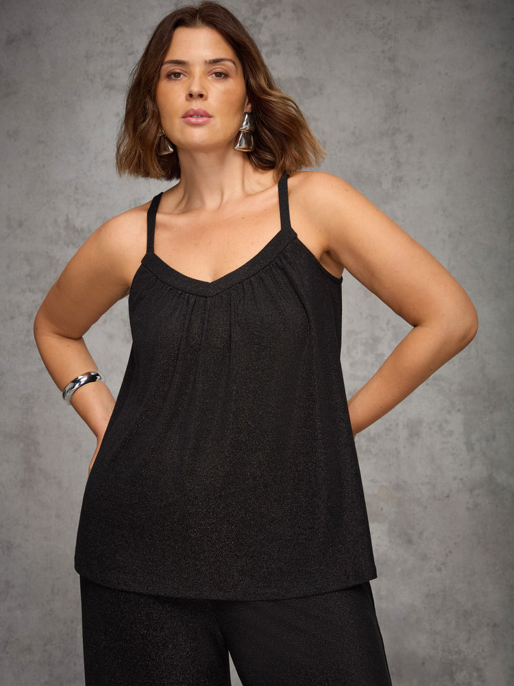 Woman wearing a black tank top against a gray background