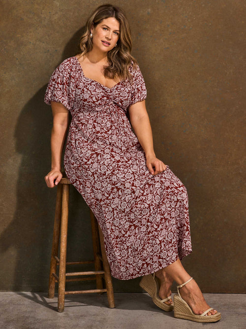 Rust floral midaxi dress styled sitting on stool