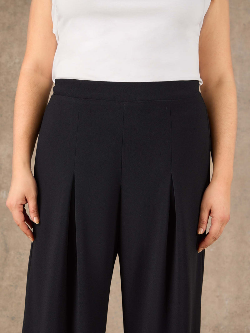 Black high rise tailored trousers with wide leg silhouette
