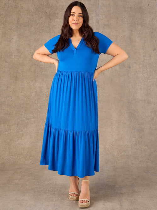Woman wearing a blue dress against a brown background