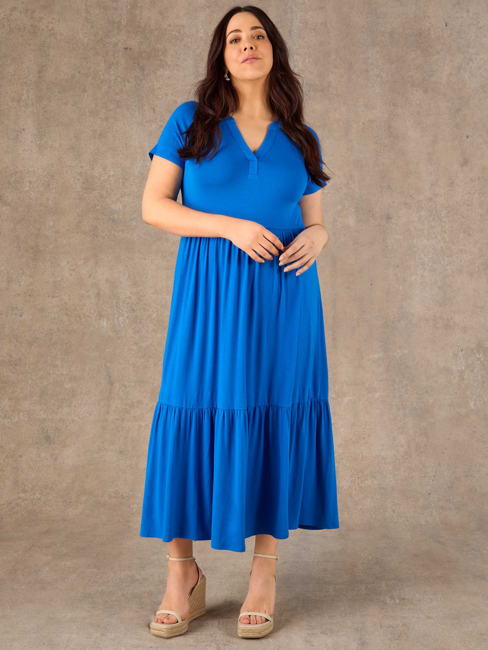 Woman wearing a blue dress against a brown background