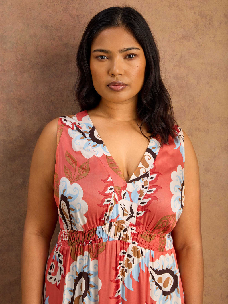 Woman wearing a floral maxi dress against a brown background