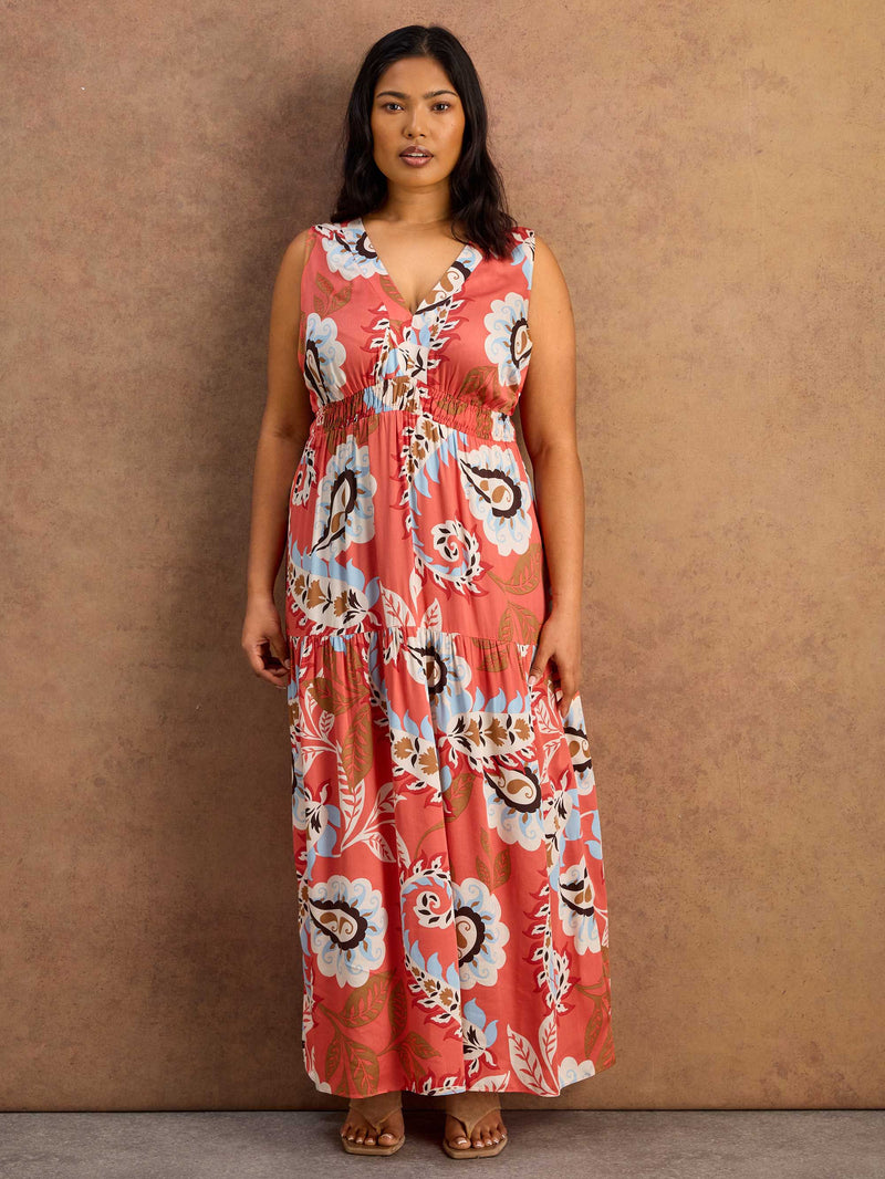 Woman wearing a floral maxi dress against a brown background
