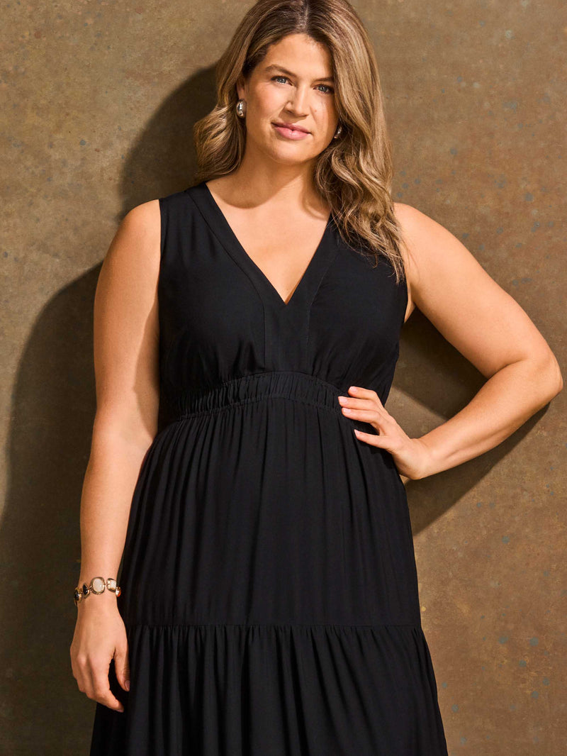Woman wearing a black dress against a brown background