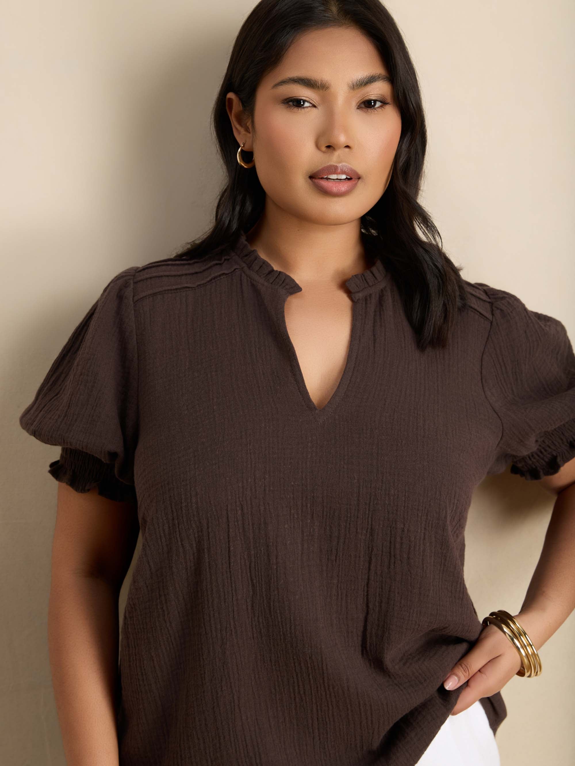 Curve blouse with a ruffle collar, V-shaped keyhole neckline, puff sleeves and shirred cuffs for a feminine finish.