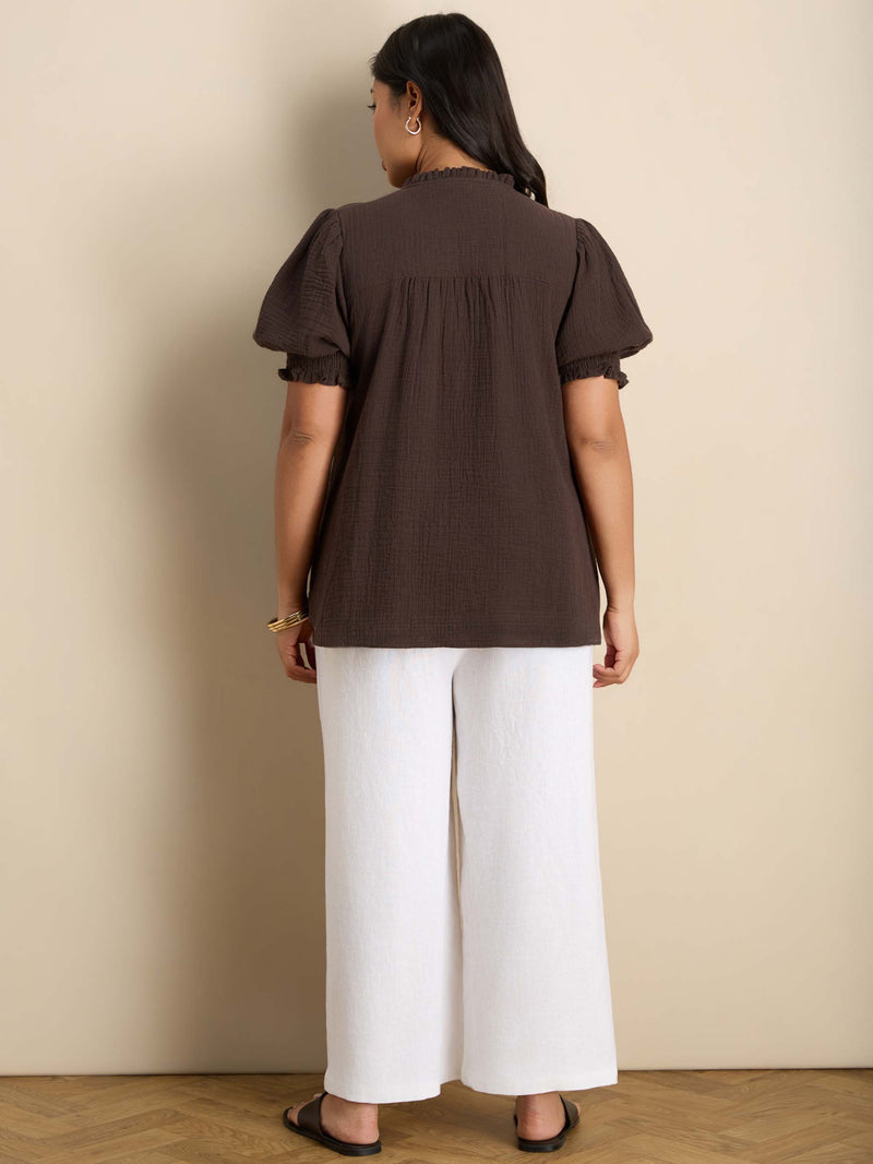 Curve blouse with a ruffle collar, V-shaped keyhole neckline, puff sleeves and shirred cuffs for a feminine finish.