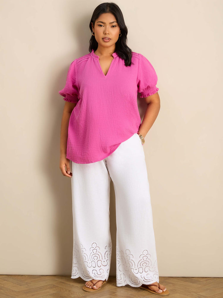 Plus size pink blouse featuring a ruffle collar, pintuck detailing and puff sleeves.