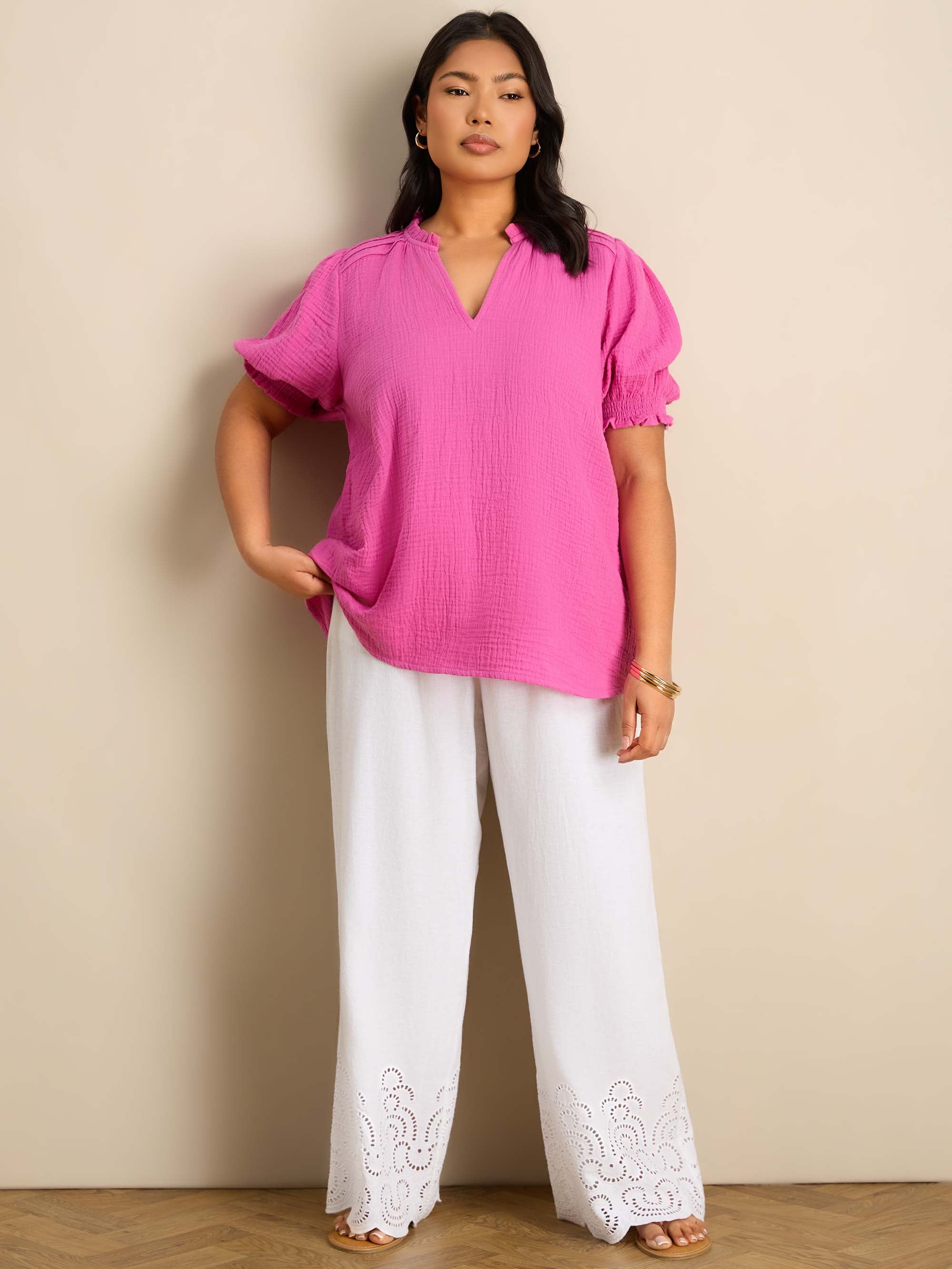 Plus size pink blouse featuring a ruffle collar, pintuck detailing and puff sleeves.