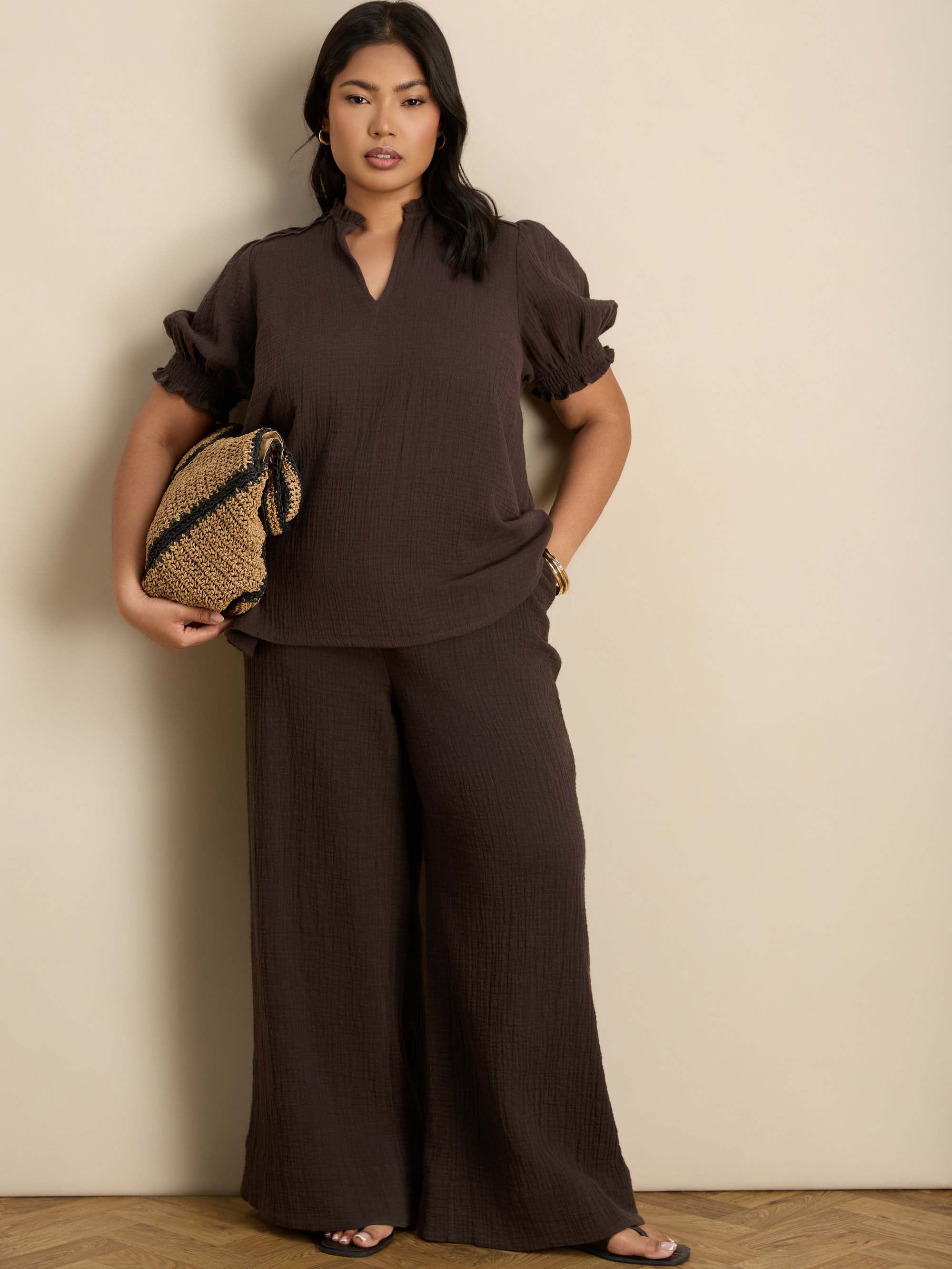 Plus size chocolate wide leg trousers featuring a flat front, gathered waist and comfortable shirred back waistband.