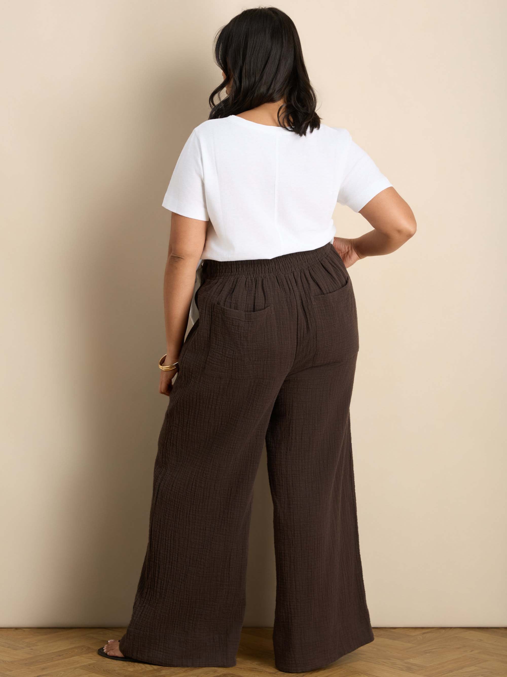 Plus size chocolate wide leg trousers featuring a flat front, gathered waist and comfortable shirred back waistband.