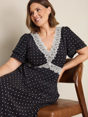 Plus size black polka dot maxi dress with lace trim, flutter sleeves and empire waist