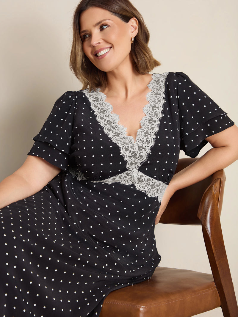 Plus size black polka dot maxi dress with lace trim, flutter sleeves and empire waist