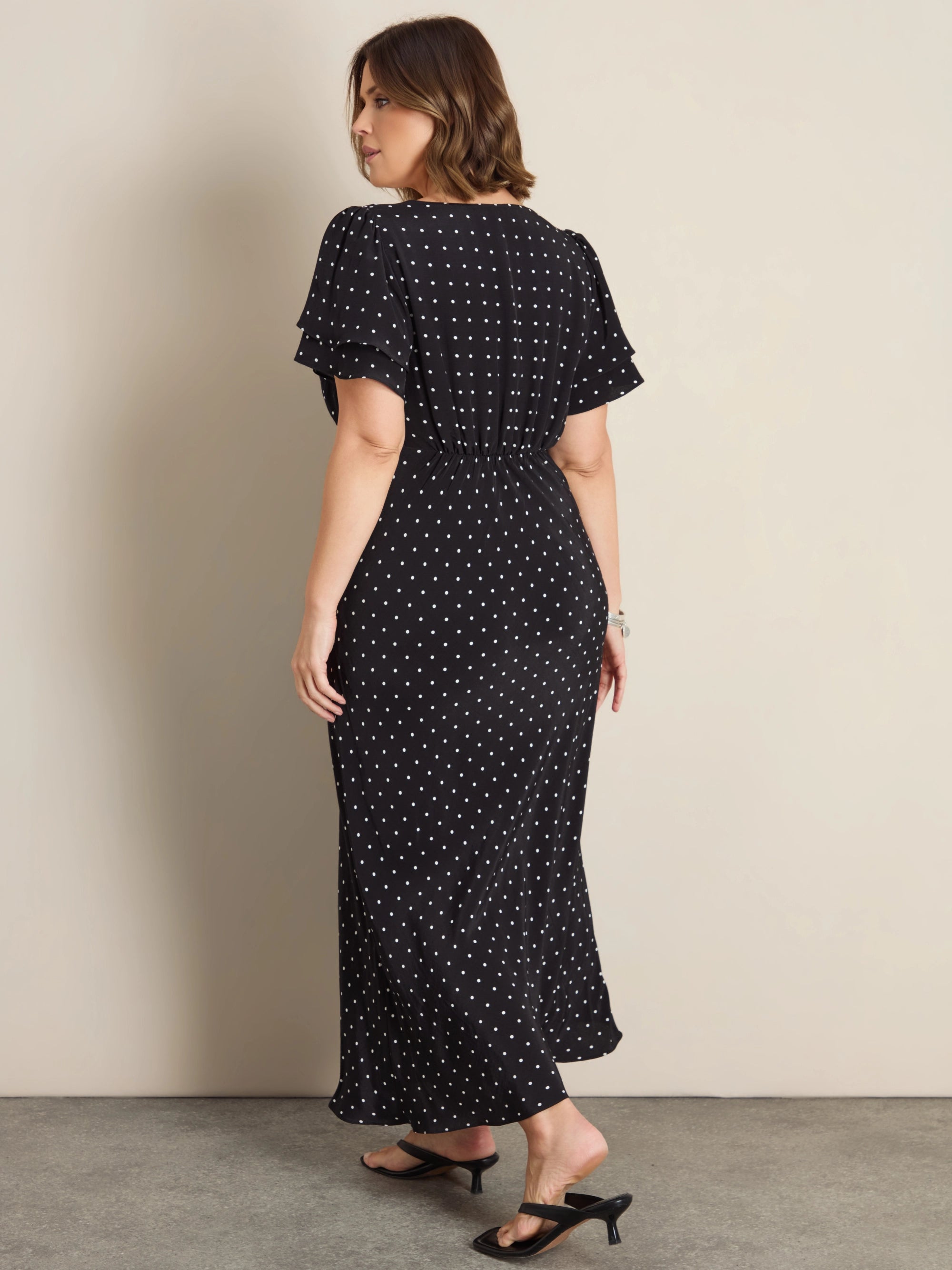 Plus size black polka dot maxi dress with lace trim, flutter sleeves and empire waist
