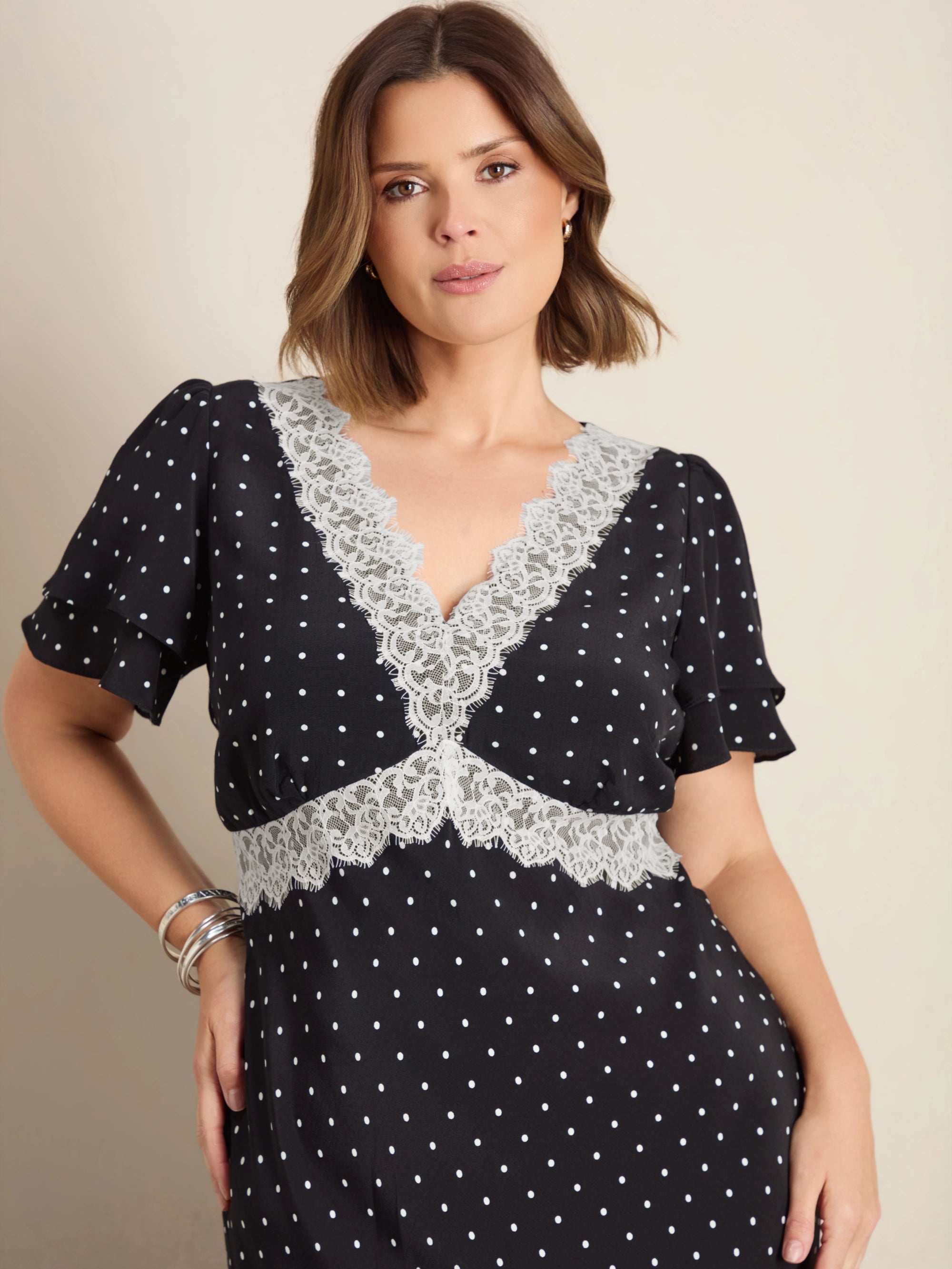 Plus size black polka dot maxi dress with lace trim, flutter sleeves and empire waist