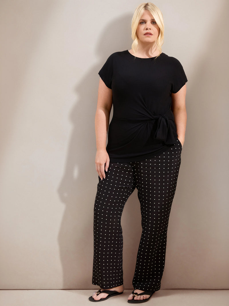 Plus size black jersey top with contrast neckline, cap sleeves and side tie detail, ideal for casual and smart-casual outfits.