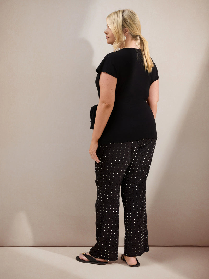 Plus size black jersey top with contrast neckline, cap sleeves and side tie detail, ideal for casual and smart-casual outfits.