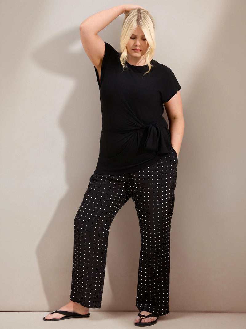 Plus size black jersey top with contrast neckline, cap sleeves and side tie detail, ideal for casual and smart-casual outfits.