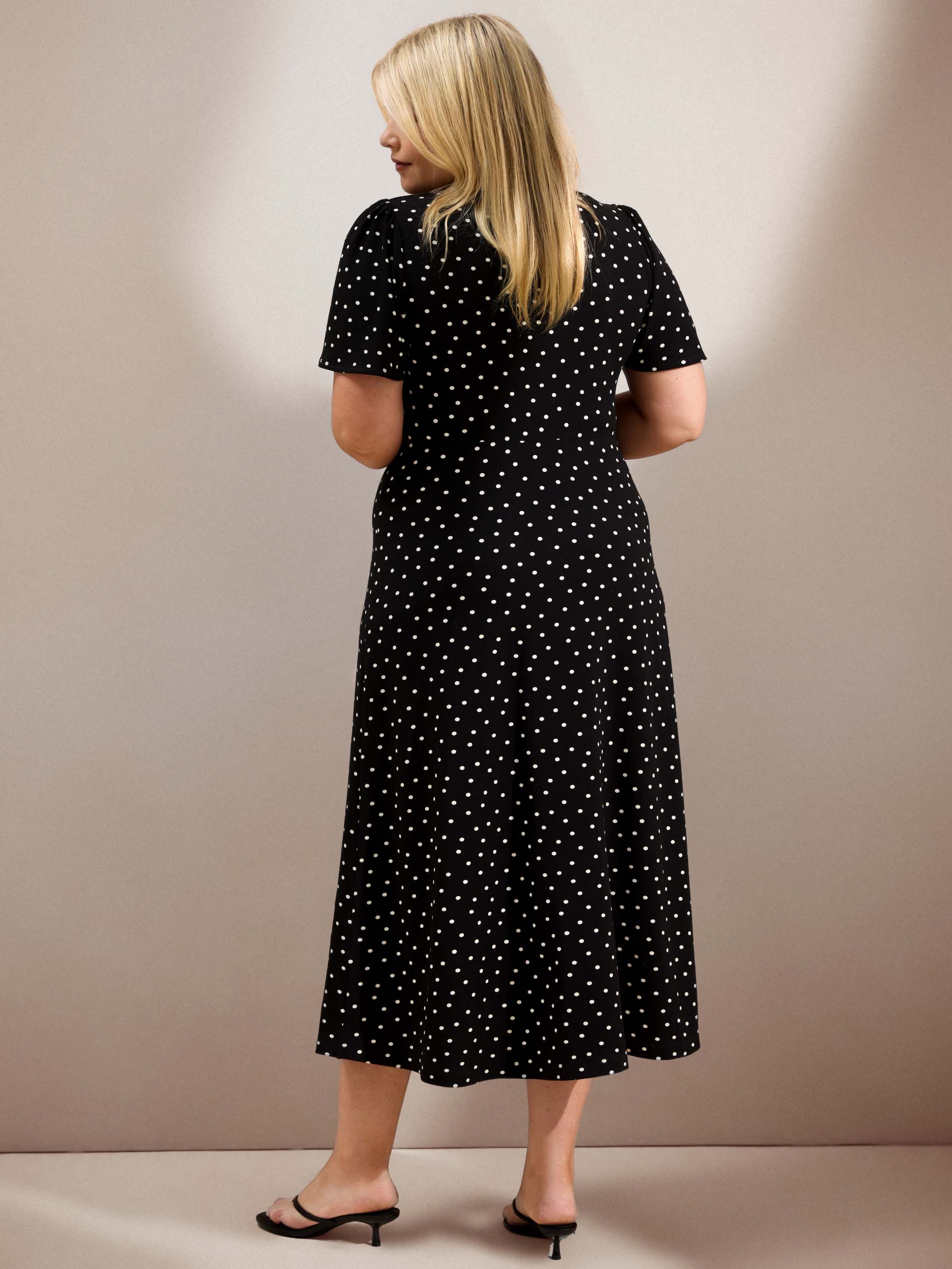 Curve black polka dot jersey midi dress with a defined waist, short flutter sleeves and flowing skirt.
