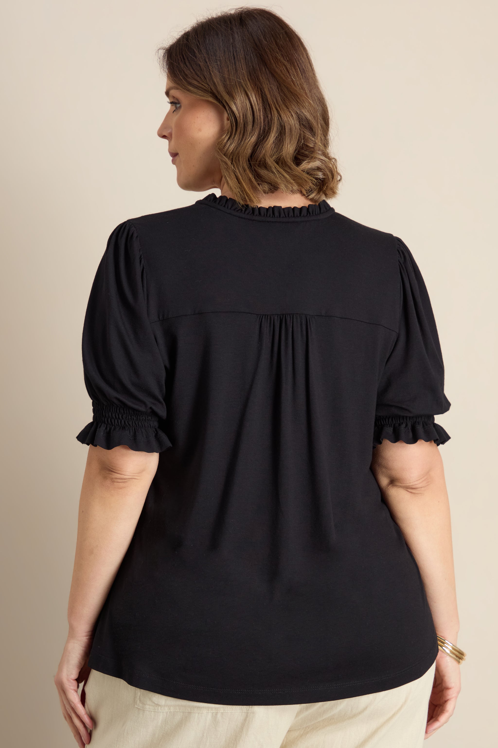 Plus size blouse with ruffle neckline, puff sleeves and gathered yoke detail