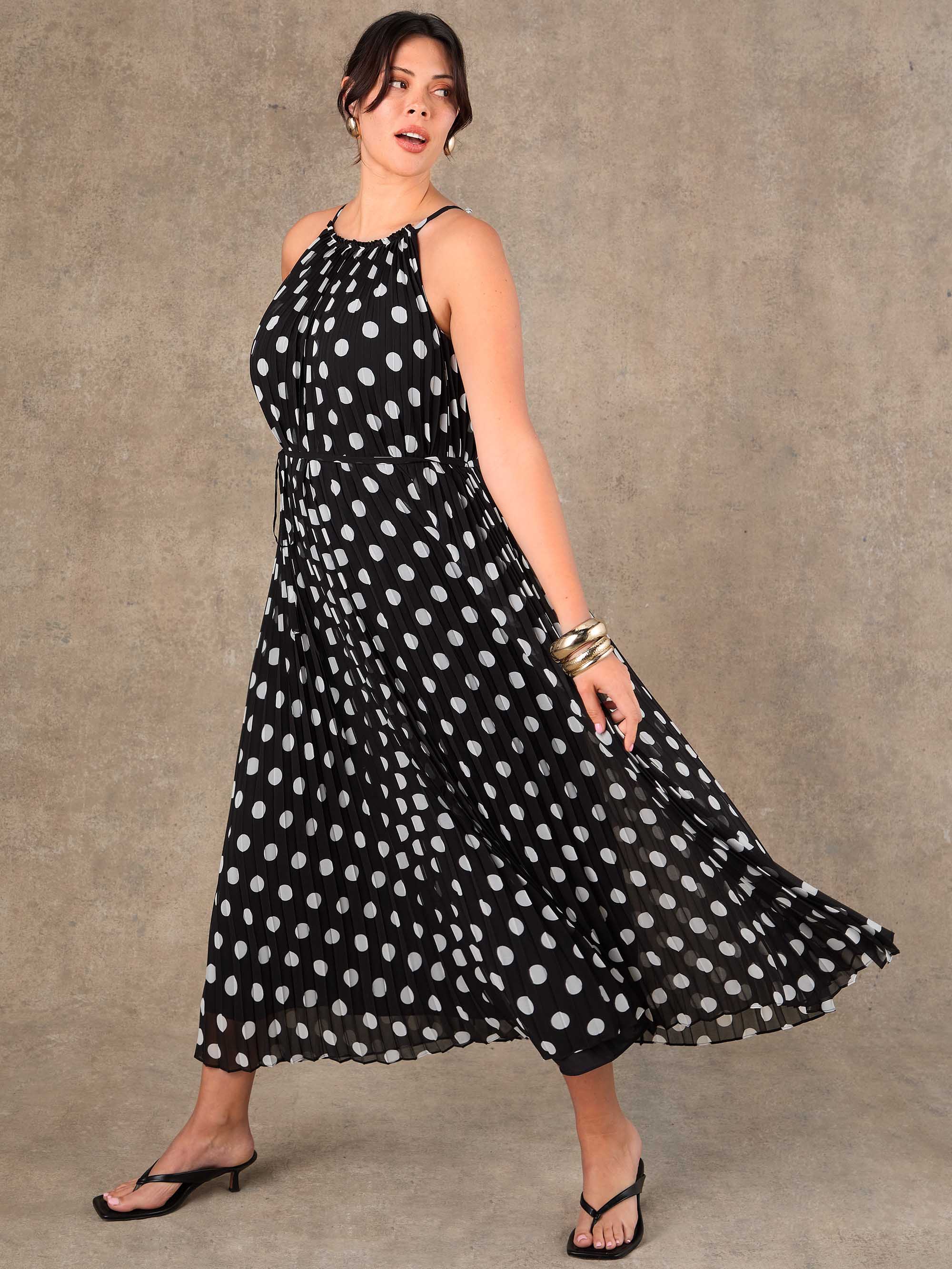 Curve fit black and white polka dot pleated maxi dress with removable tie belt for special occasions.